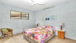a bedroom with a bed and a white brick wall at The Cove in Scotts Head
