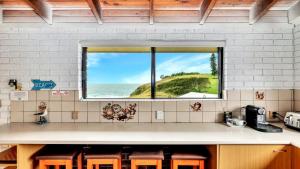 a kitchen with a view of the ocean from a window at The Cove in Scotts Head