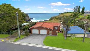 a house on a hill next to the ocean at The Cove in Scotts Head