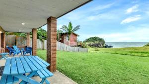 a blue picnic table on a patio with a view of the ocean at The Cove in Scotts Head +8 photos