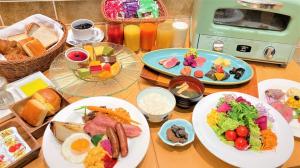 a wooden table with plates of food on it at Hotel Monterey Kobe in Kobe