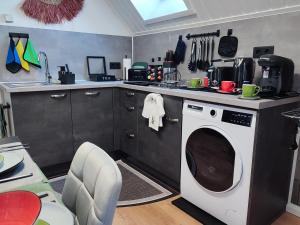 a kitchen with a washing machine in a kitchen at GlanzExperts Auszeit bei Berlin Balkon Kicker & DisneyPlus in Zossen