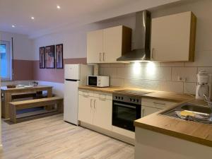 a kitchen with white cabinets and a stove top oven at Schöne Ferienwohnung bei Lennestadt in Kirchhundem
