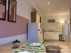a kitchen with a table and a white refrigerator at Schöne Ferienwohnung bei Lennestadt in Kirchhundem +16 photos