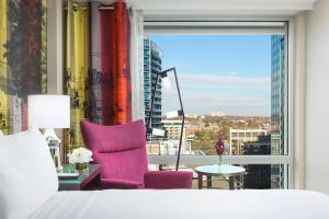 a bedroom with a bed and a chair and a window at Hyatt Centric Arlington in Arlington