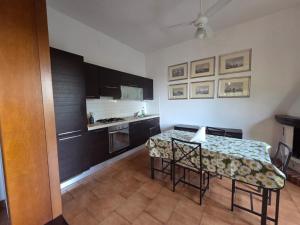 eine Küche mit einem Tisch und einigen Stühlen und einem Tisch und einer Küche in der Unterkunft Beachside Villa in Quercianella