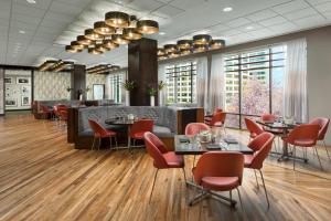 a restaurant with tables and chairs and windows at Hyatt Centric Arlington in Arlington