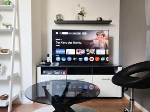 a glass table in front of a tv in a living room at GlanzExperts Auszeit bei Berlin Balkon Kicker & DisneyPlus in Zossen