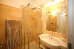 ein Badezimmer mit Glasdusche und Waschbecken in der Unterkunft Palace Hotel Vieste in Vieste + 18 Fotos