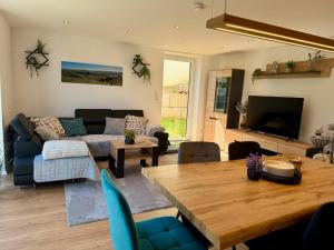 a living room with a table and a couch at Ferienwohnung zum Buchfeld in Windesheim
