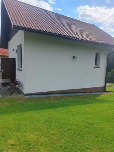 a white building with a red roof at Apartament Panorama - noclegi blisko Energylandii in Bachowice +2 photos