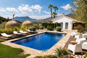 a backyard with a pool with chairs and a house at Finca Dariana Padel & Pool in Alora
