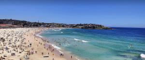 a group of people on a beach in the ocean at Cozy Bondi ROOM - Beach life and Local Host! Free Parking in Sydney
