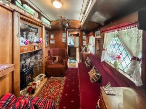a train room with a couch and a chair at Molly the Showman's Wagon in Hailsham