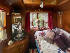 a bedroom with a bed and a window at Molly the Showman's Wagon in Hailsham