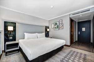 a bedroom with a large white bed in a room at Doubletree By Hilton London Kensington in London +44 photos