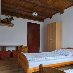 a bedroom with a bed and a wooden ceiling at Pod Smerekiem in Wetlina
