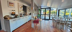 a kitchen with blue cabinets and a table and chairs at Logis Le Nid du Pont de Gau in Saintes-Maries-de-la-Mer