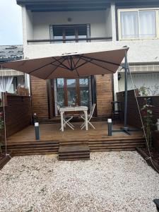 a patio with a white table and an umbrella at Studio avec cheminée et jardin in Gréolières
