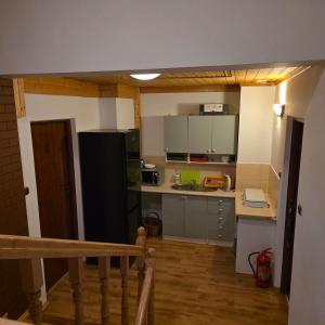 a small kitchen with a black refrigerator and gray cabinets at Pod Smerekiem in Wetlina