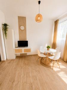 a living room with a table and chairs and a television at Apartament Panorama - noclegi blisko Energylandii in Bachowice