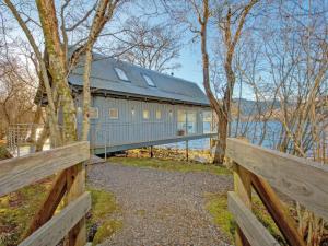 a blue barn with a fence and trees at Dipper Boathouse in Acharn