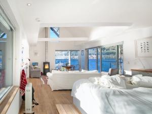 a bedroom with two beds and a living room at Dipper Boathouse in Acharn