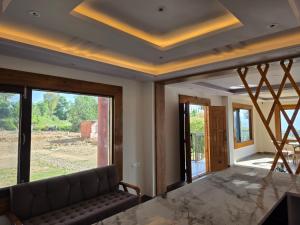 a living room with a couch and a large window at Rahini sunset villa in Shimla