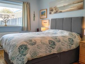 a bedroom with a large bed and a window at Dihangfa Wylau in Tywyn