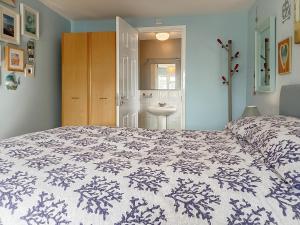 a bedroom with a large bed and a bathroom at Dihangfa Wylau in Tywyn