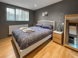 a bedroom with a bed and a dresser and a mirror at Bellstane Chalet - Ukc9440 in Glasgow +8 photos