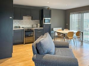 a kitchen and living room with a couch and a table at Bellstane Chalet - Ukc9440 in Glasgow