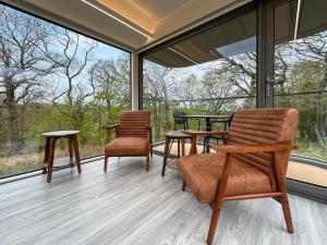 a screened in porch with two chairs and a table at Vessel 2 - Ukc9442 in Glasgow