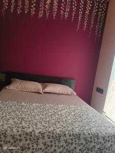 a bedroom with a bed with a purple wall at Sri Skandaa in Sringeri +7 photos