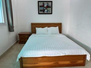 a bedroom with a large bed with a wooden frame at Sông Kinh Hotel - Hồ Tràm in Xóm Trương Quít