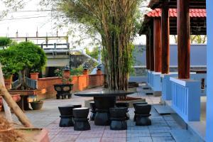 a patio with a table and chairs and a tree at Sông Kinh Hotel - Hồ Tràm in Xóm Trương Quít