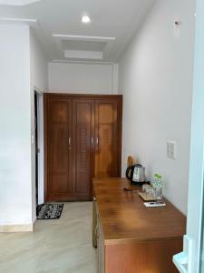 a kitchen with a wooden counter and a wooden cabinet at Sông Kinh Hotel - Hồ Tràm in Xóm Trương Quít