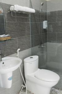 a bathroom with a white toilet and a sink at Sông Kinh Hotel - Hồ Tràm in Xóm Trương Quít +4 photos