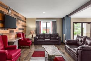 a living room with leather furniture and a flat screen tv at Ramada by Wyndham San Antonio Near SeaWorld - Lackland AFB in San Antonio