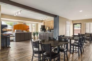 a kitchen and dining room with tables and chairs at Ramada by Wyndham San Antonio Near SeaWorld - Lackland AFB in San Antonio