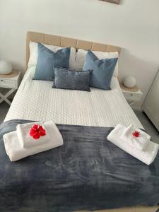 a bed with two white towels with red flowers on them at Flip flops in Horseshoe Bay +20 photos