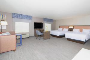 a hotel room with two beds and a flat screen tv at Hampton Inn Rawlins in Rawlins