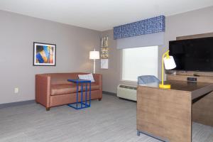 a hotel room with a living area with a flat screen tv at Hampton Inn Rawlins in Rawlins