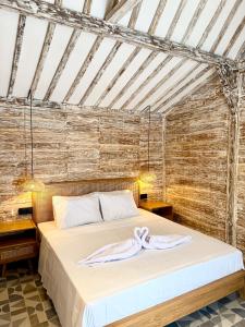 a bed in a room with a brick wall at ADIBA village in Gili Meno