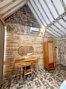 a desk in a room with a brick wall at ADIBA village in Gili Meno