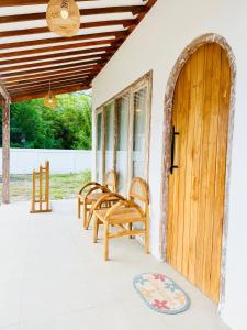 a porch with chairs and a wooden door at ADIBA village in Gili Meno +71 photos