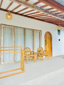 a table and chairs in a room with windows at ADIBA village in Gili Meno