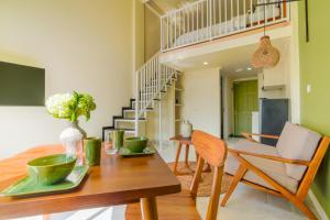 a dining room with a table and chairs and a staircase at Nagomi Studio Nyanyi in Cemagi