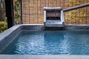 a small pool of water with a bird feeder at Yufuin Yasuha in Yufu