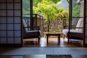 a room with two chairs and a table on a balcony at Yufuin Yasuha in Yufu +86 photos
